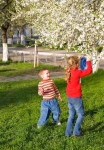 Happy small children in spring recreation ground